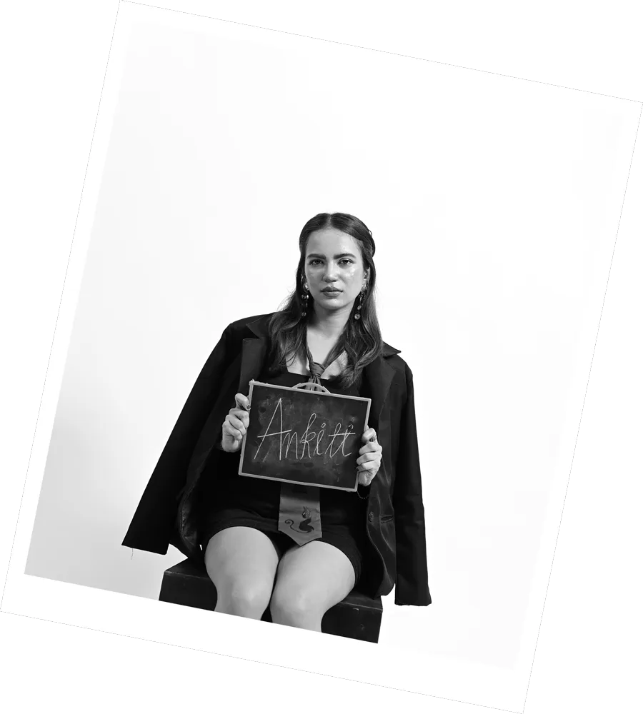 A Kazi team member seated holding a hand-lettered name card