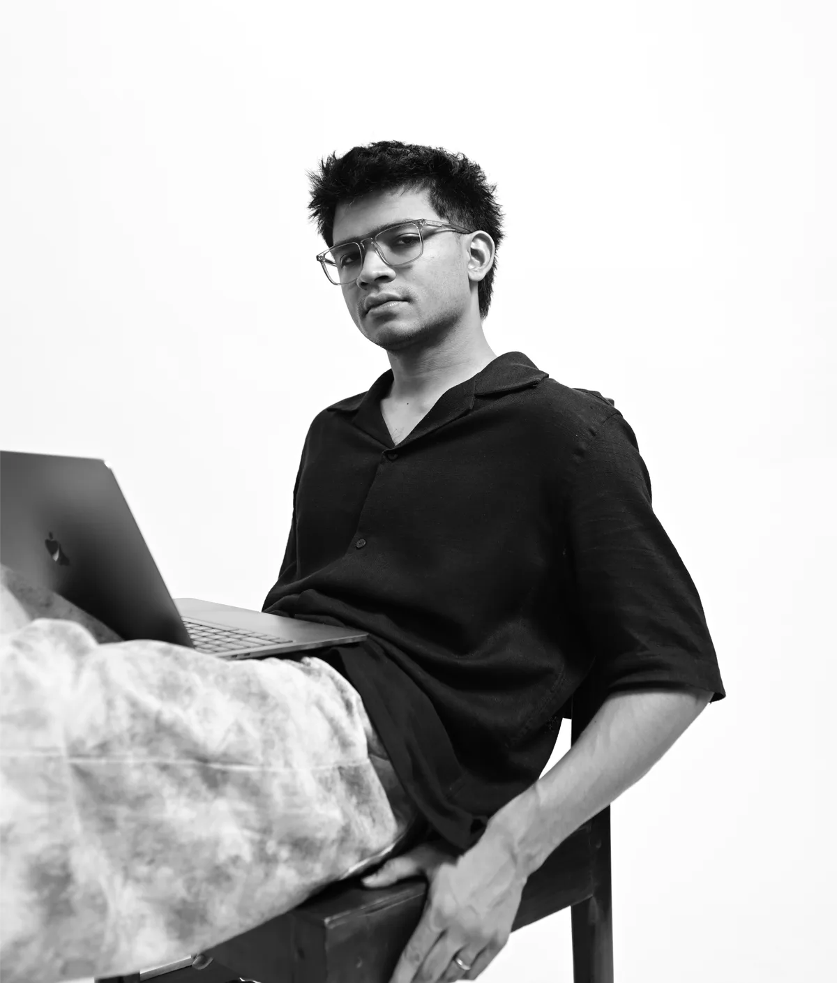 Vikram Aditya Saikia seated with a laptop, photographed in black and white