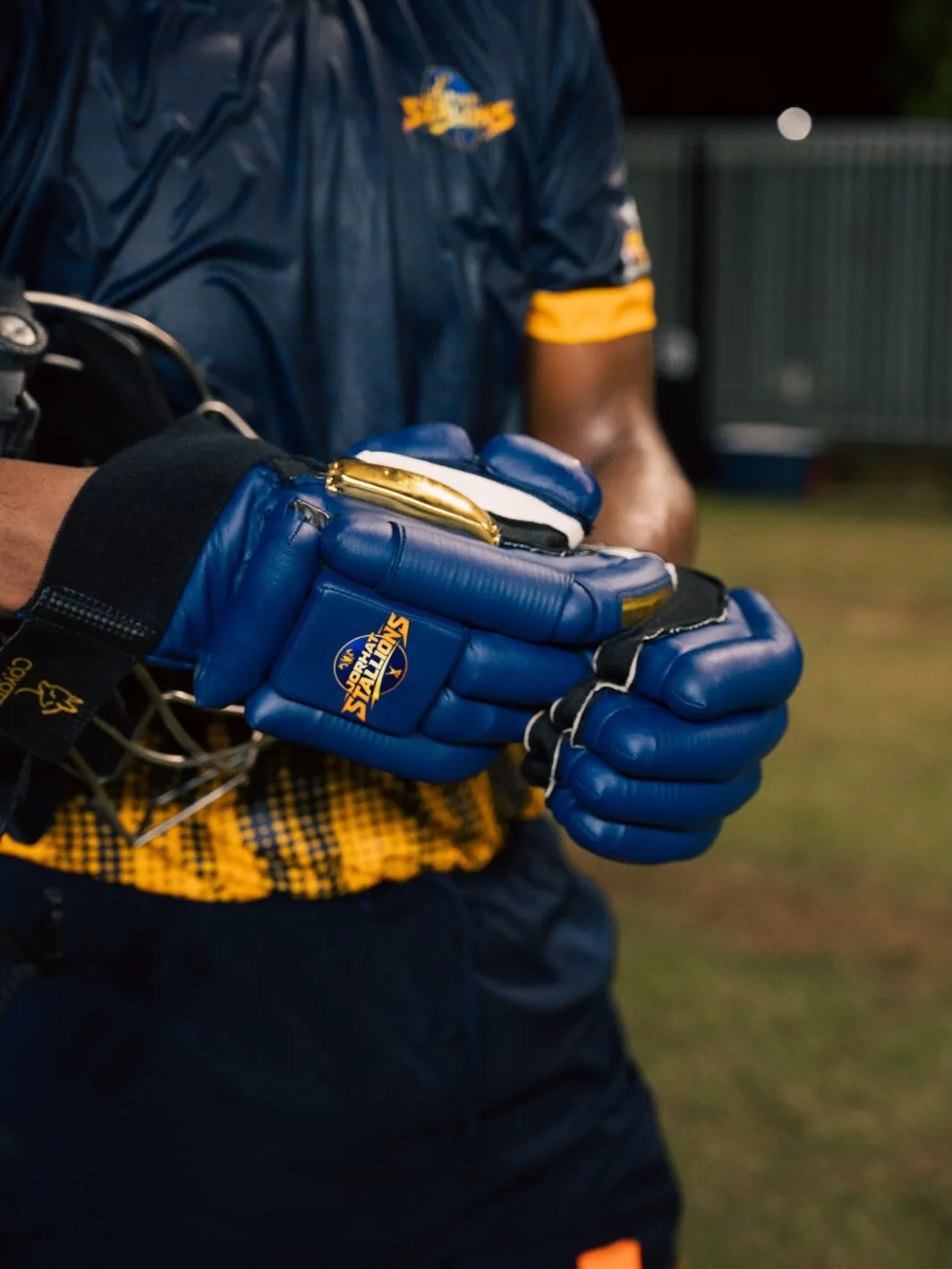 Jorhat Stallions batter strapping on blue batting gloves