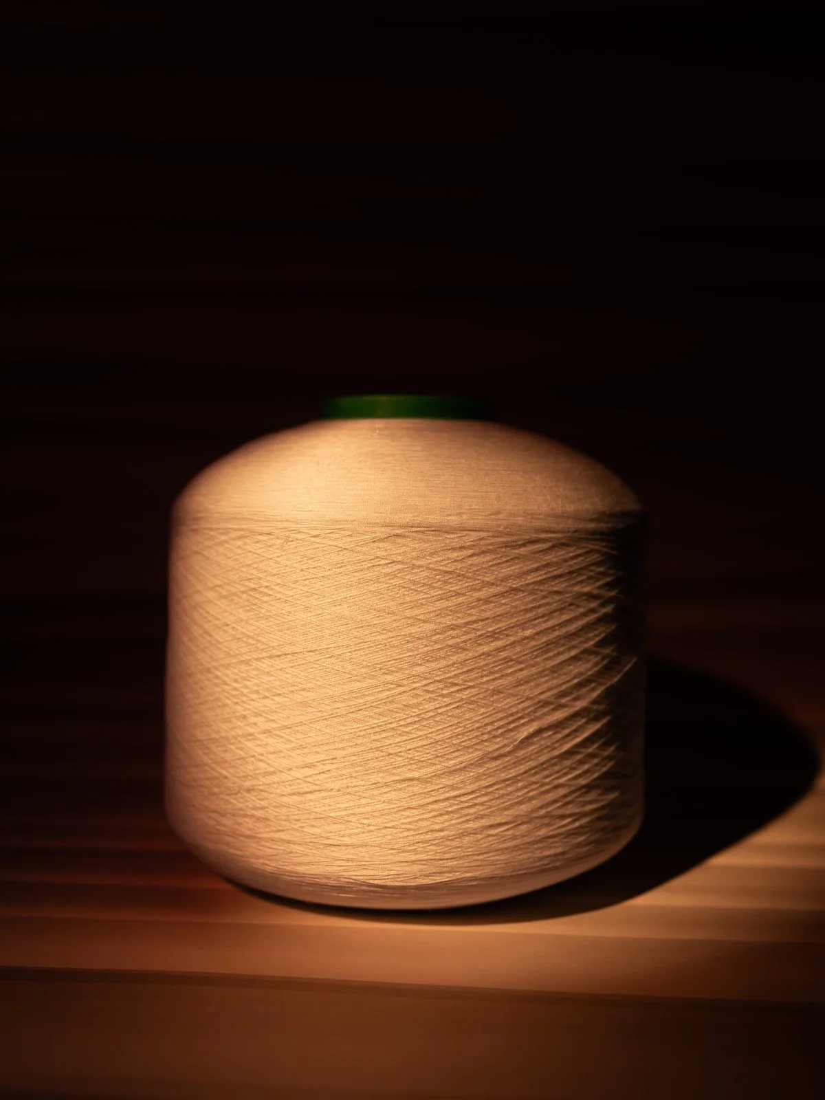 Beige yarn cone in dramatic light