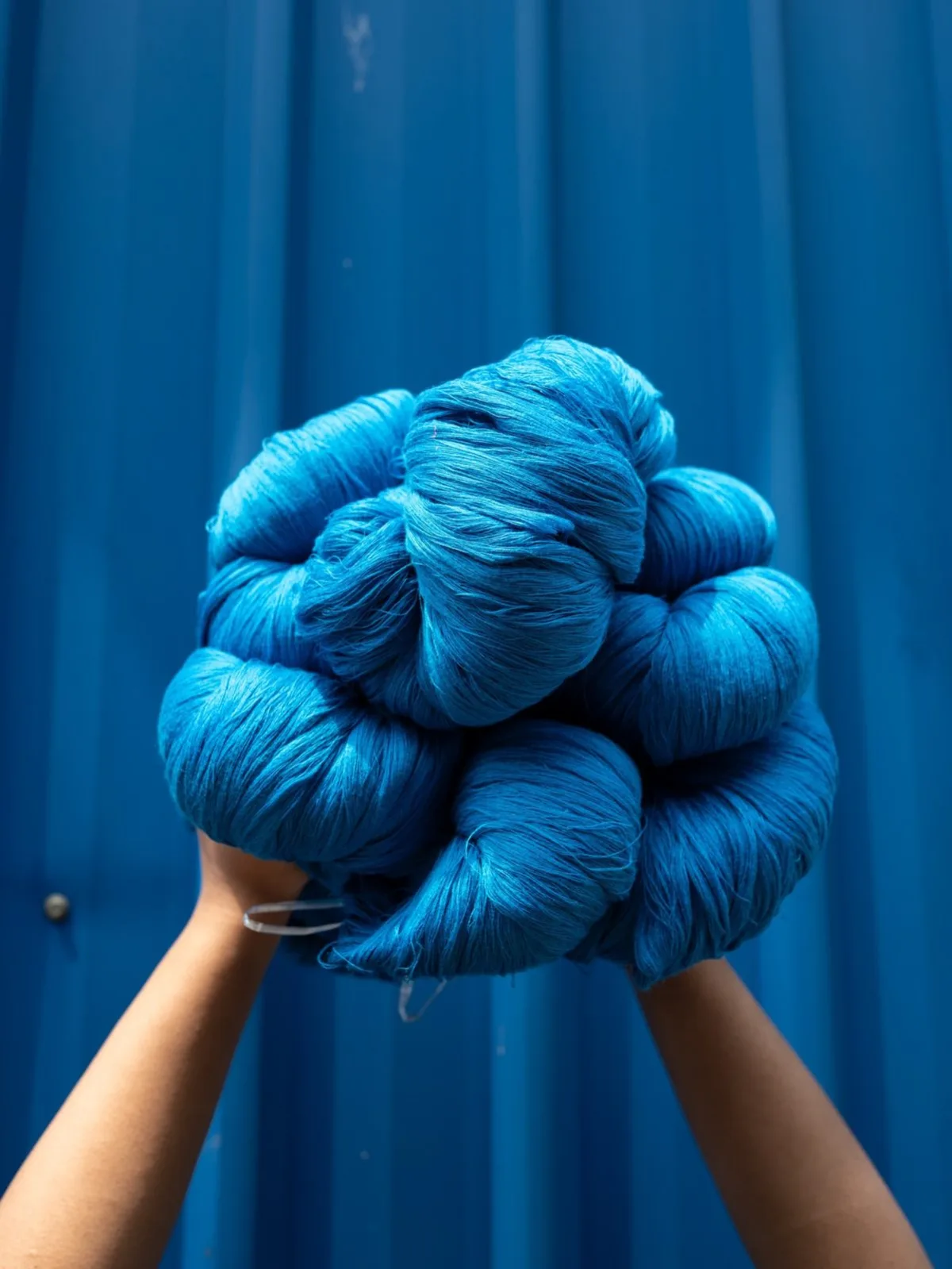 Blue yarn bundle raised against a blue container