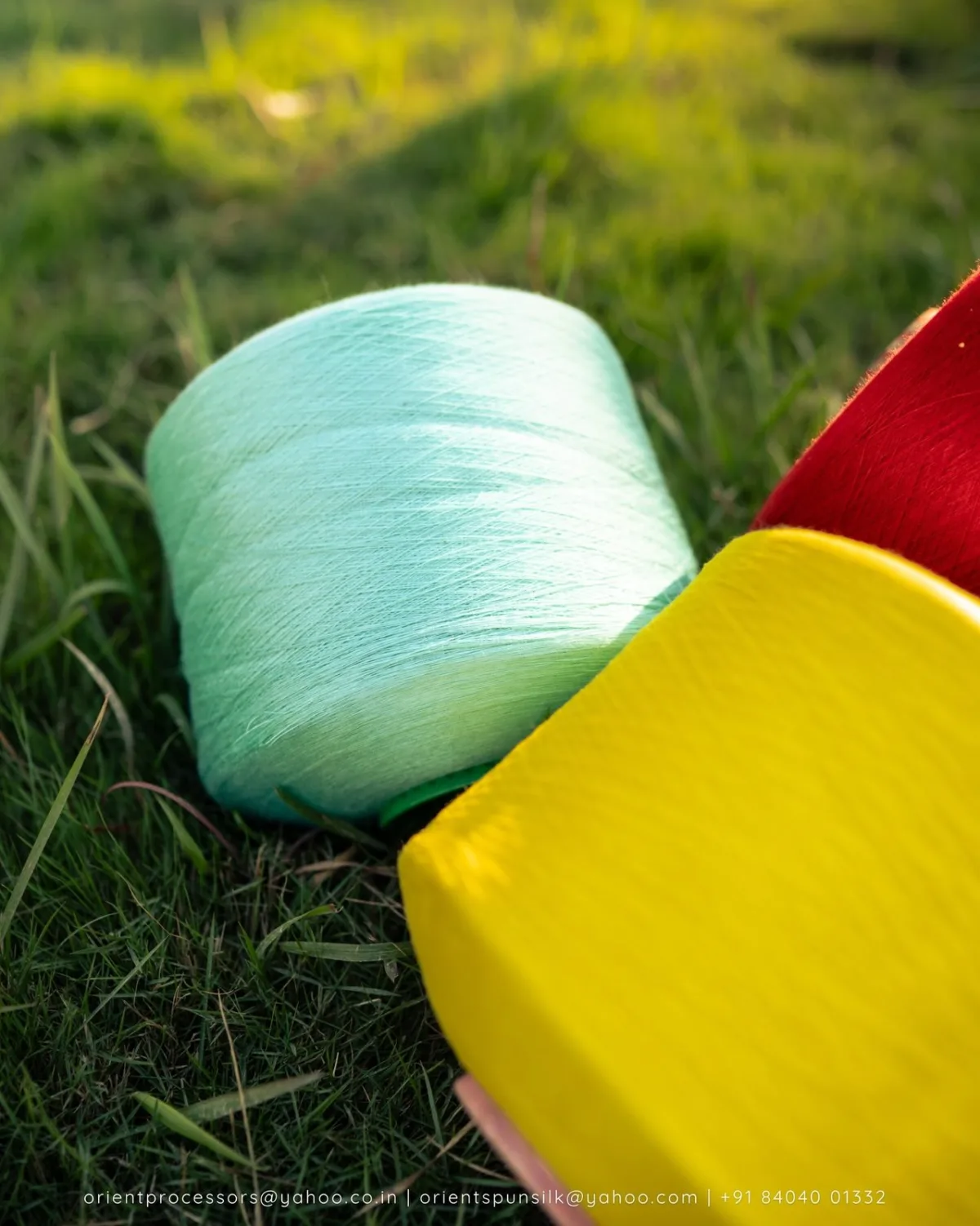 Mint, yellow and red yarn cones on grass