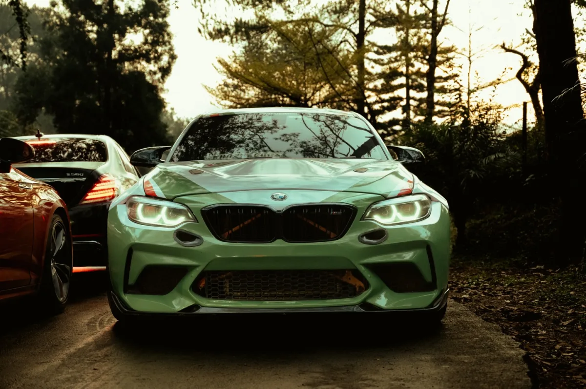 Green BMW M2 head-on in the woods